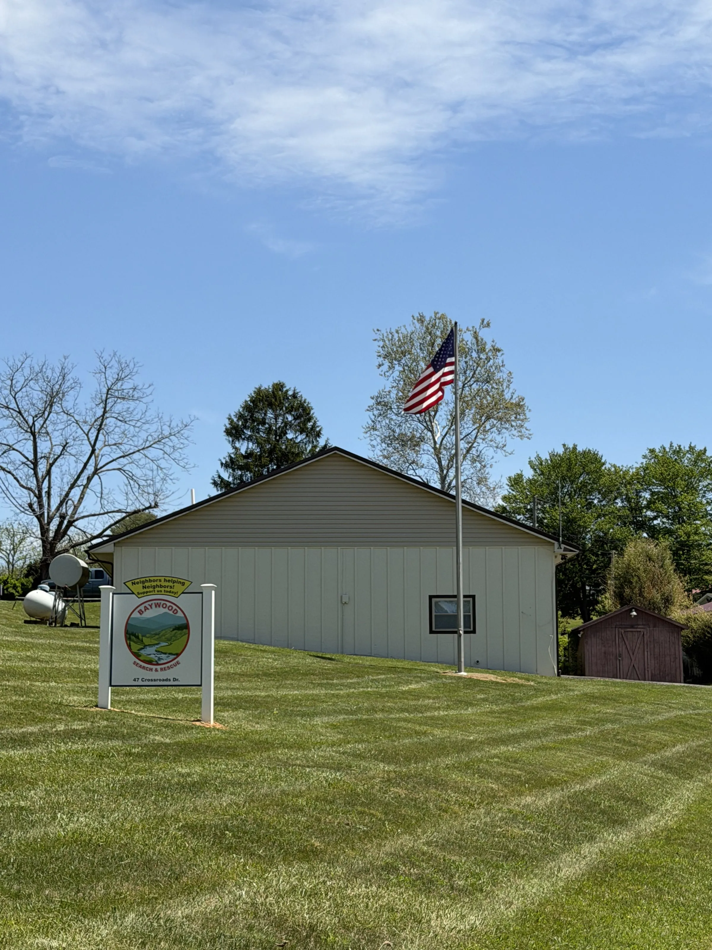 Side view of the Baywood Search and Rescue station with the Neighbors Helping Neighbors sign in the foreground